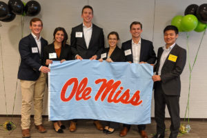 group of student interns holding Ole Miss flag